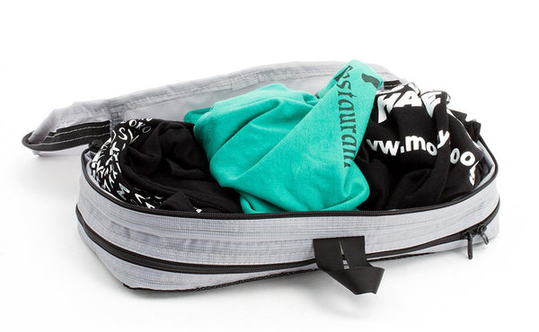 A filled and open Northwest Sky (light grey) Aether Small Aeronaut 30 Packing Cube holding three folded shirts on the all-fabric side.
